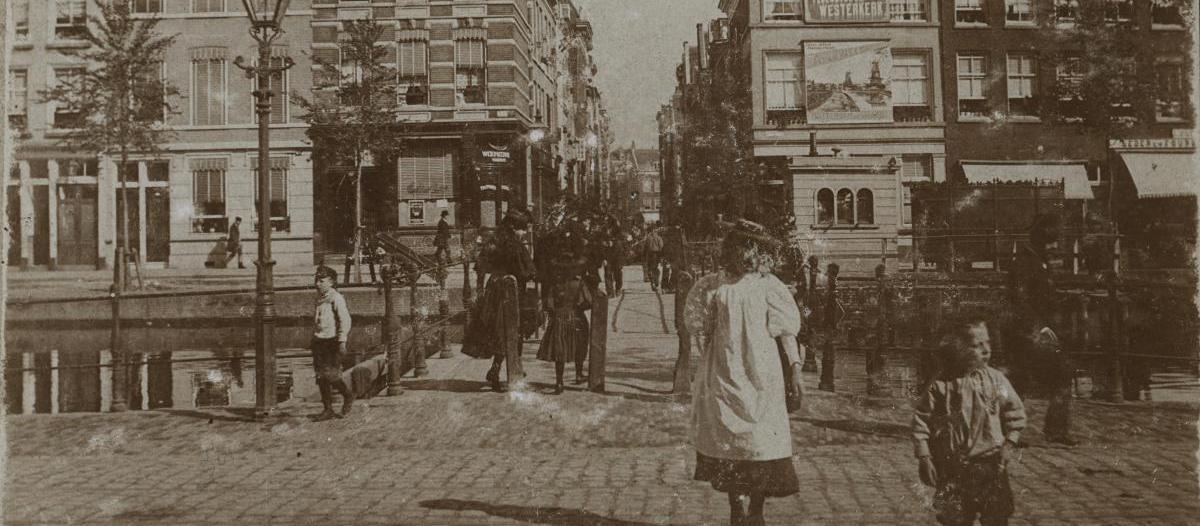 Straatfoto van De Coolvest omstreeks 1900 met wandelaars.