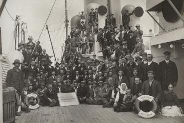 Groepsfoto van emigranten op dek van het schip.