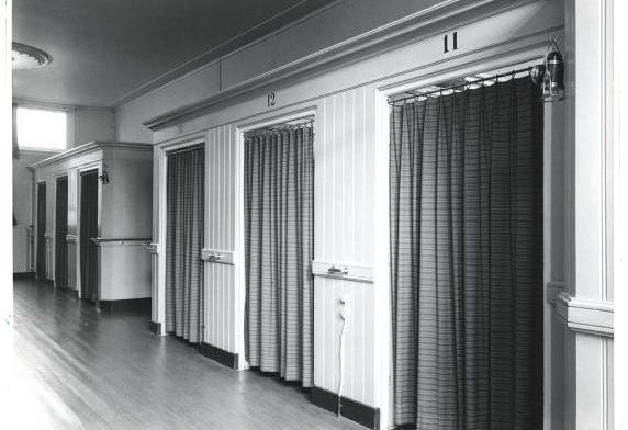 Foto van een ruimte met zes slaapkamers, met gordijnen in plaats van deuren.