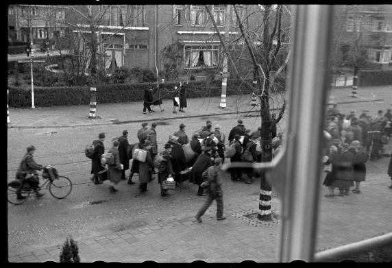 Mannen worden weggevoerd tijdens de razzia.