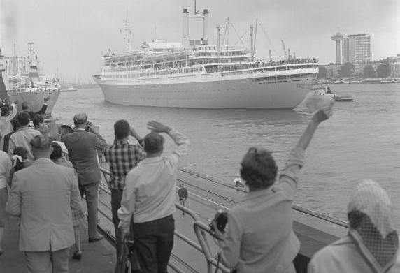 Afvaart van de ss Rotterdam. Op de voorgrond staan mensen uit te zwaaien.