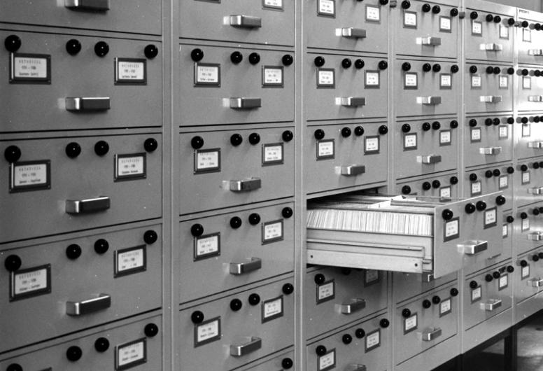 Op deze foto zijn de kasten te zien waarin de papieren index op het notarieel archief van Rotterdam zit. Het is een wand van vele kasten met zes lades vol met indexkaartjes.