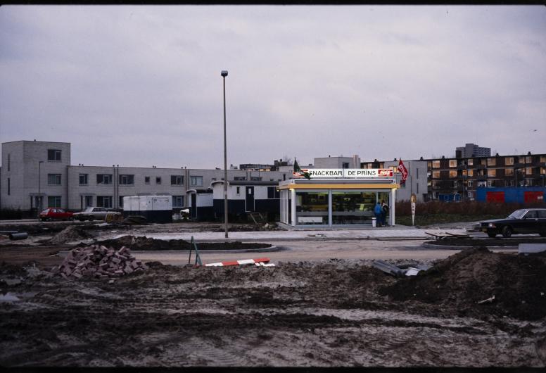 foto van een snackbar met op de voorgrond opengebroken grond voor woningbouw