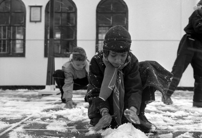 Met de Sibajak uit Indonesie aangekomen kinderen maken op de Lloydkade kennis met sneeuw (1958). Fotograaf Ary Groeneveld, collectie 4121, nummer 1192-4-01