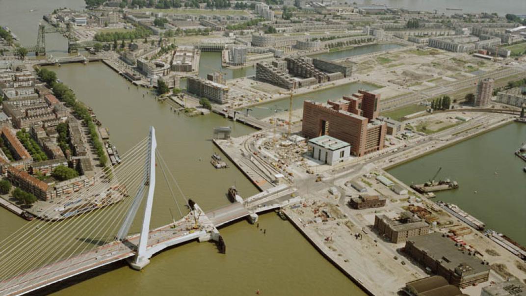 Luchtfoto met een overzicht van de Erasmusbrug, het Noordereiland en de Kop van Zuid, gezien vanuit het westen.